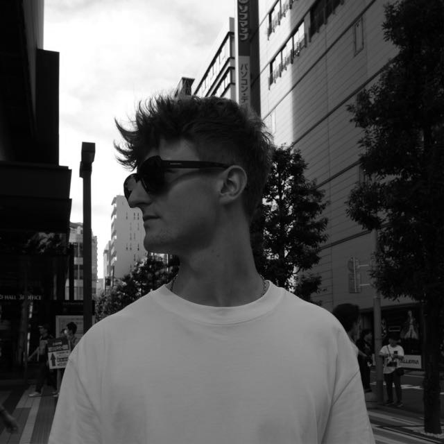 Junger Mann mit Sonnenbrille in urbaner Umgebung, Schwarz-Weiß-Foto.